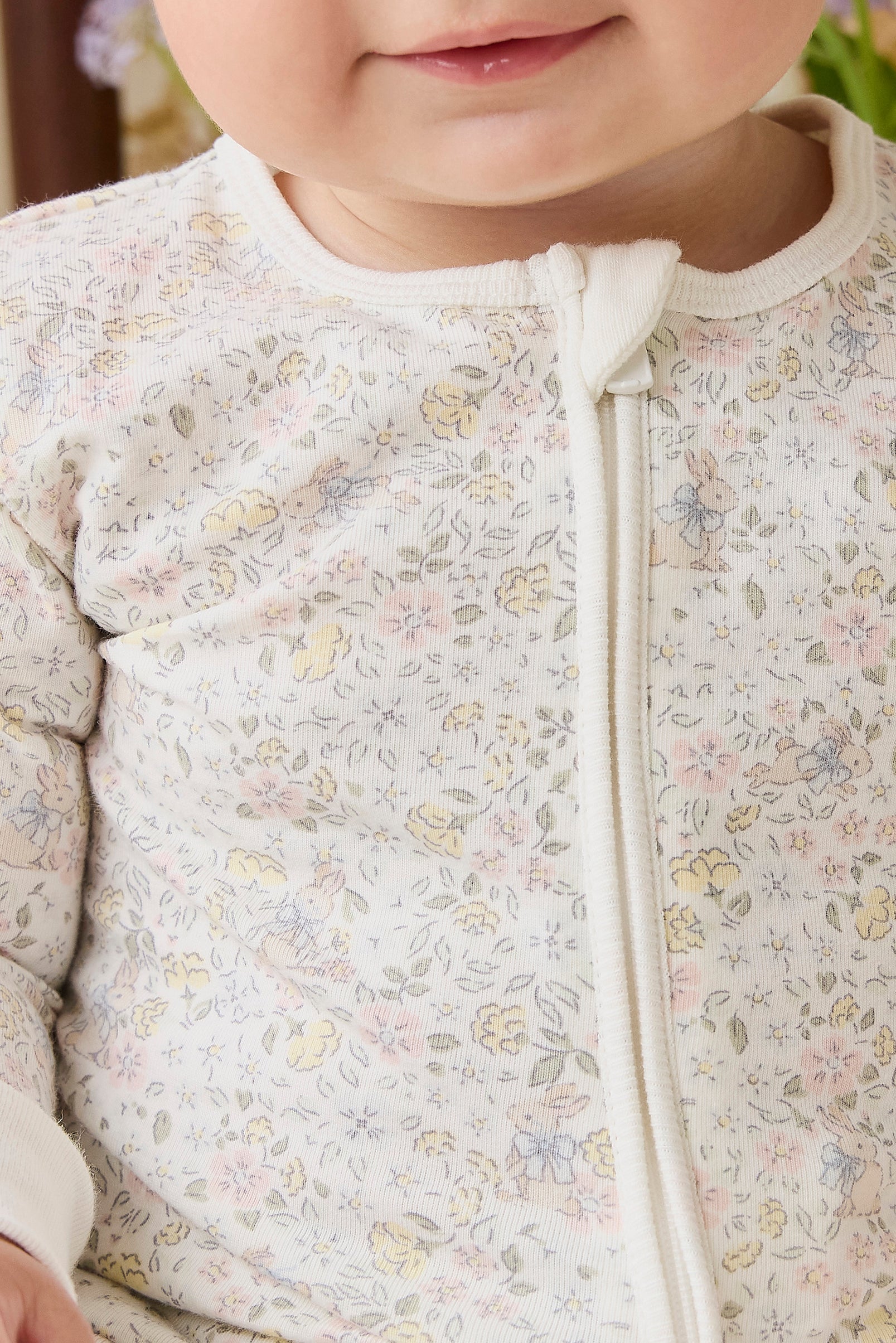 Barboteuse en coton biologique et élasthanne à motif floral délicat et neutre, avec fermeture éclair avant sur toute la longueur, pour le quotidien de bébé (0-3 ans)