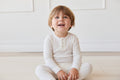 Haut Henley à manches longues en coton modal biologique pour bébé et fille, coloris Milk Solid, avec patte de boutonnage et toucher doux et soyeux, idéal pour superposer (6M–10A)